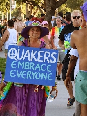 Woman holding sign saying "Quakers Embrace Everyone"